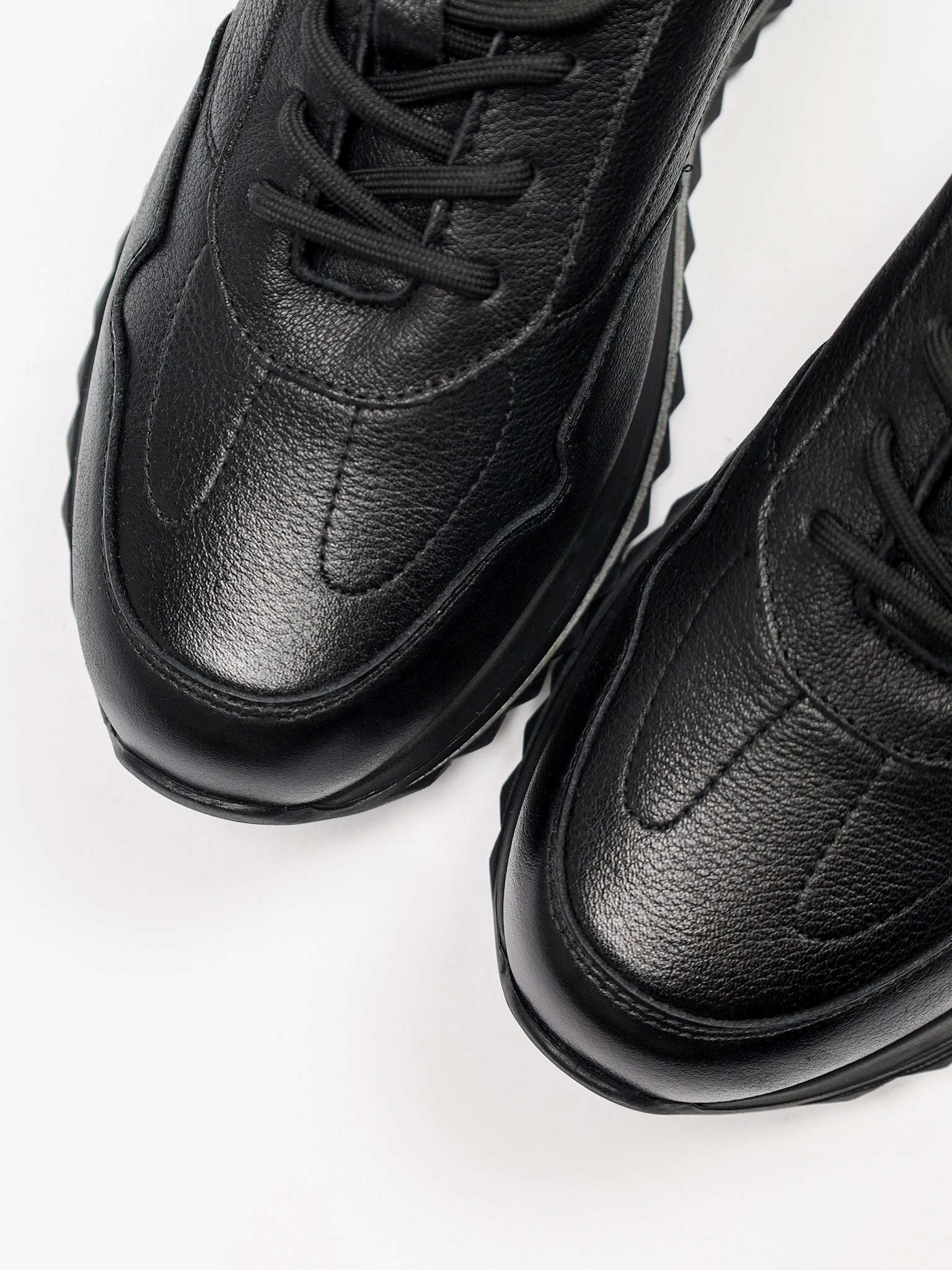 Кроссовки черного цвета на низкой рельефной подошве